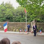 La Maire et le porte drapeau devant le monument au mort et face au public