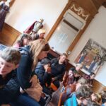 Les jeunes et l'équipe assis sur des chaises dans une salle du château