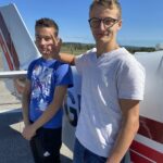 Les deux jeunes posent devant l'avion