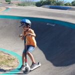 Un jeune sur le parcours de pumptrack avec sa trottinette