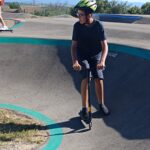 Un jeune sur le parcours de pumptrack avec sa trottinette