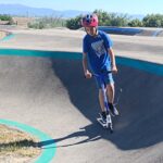 Un jeune sur le parcours de pumptrack avec sa trottinette