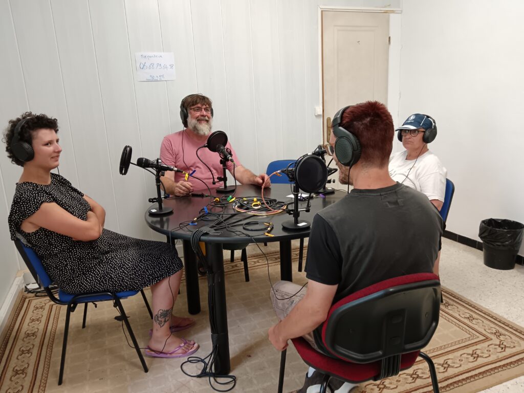 Trois résidents autour d'une table avec l'animateur radio pendant l'interview