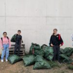 5 jeunes entourés de sacs poubelles plein de déchets