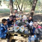 Pique-nique en plein air, au bord du lac, assis autour d'une table en bois