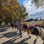 Les encadrants, à pied, accompagnent les enfants sur les poneys