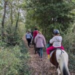 Les encadrants, à pied, accompagnent les enfants sur les poneys