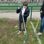 Un jeune ramasse les déchets avec une pince