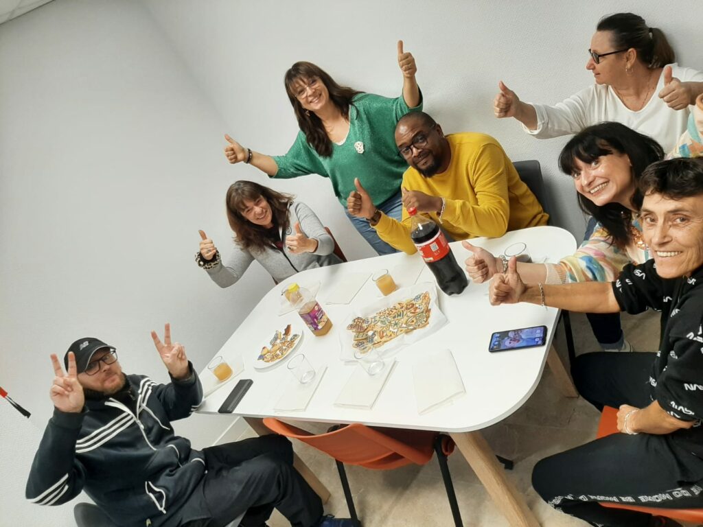 7 personnes autour de la table partagent le goûter de Noël