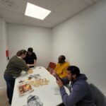 Autour de la table, 4 personnes s'appliquent à la confection des sablés de Noël