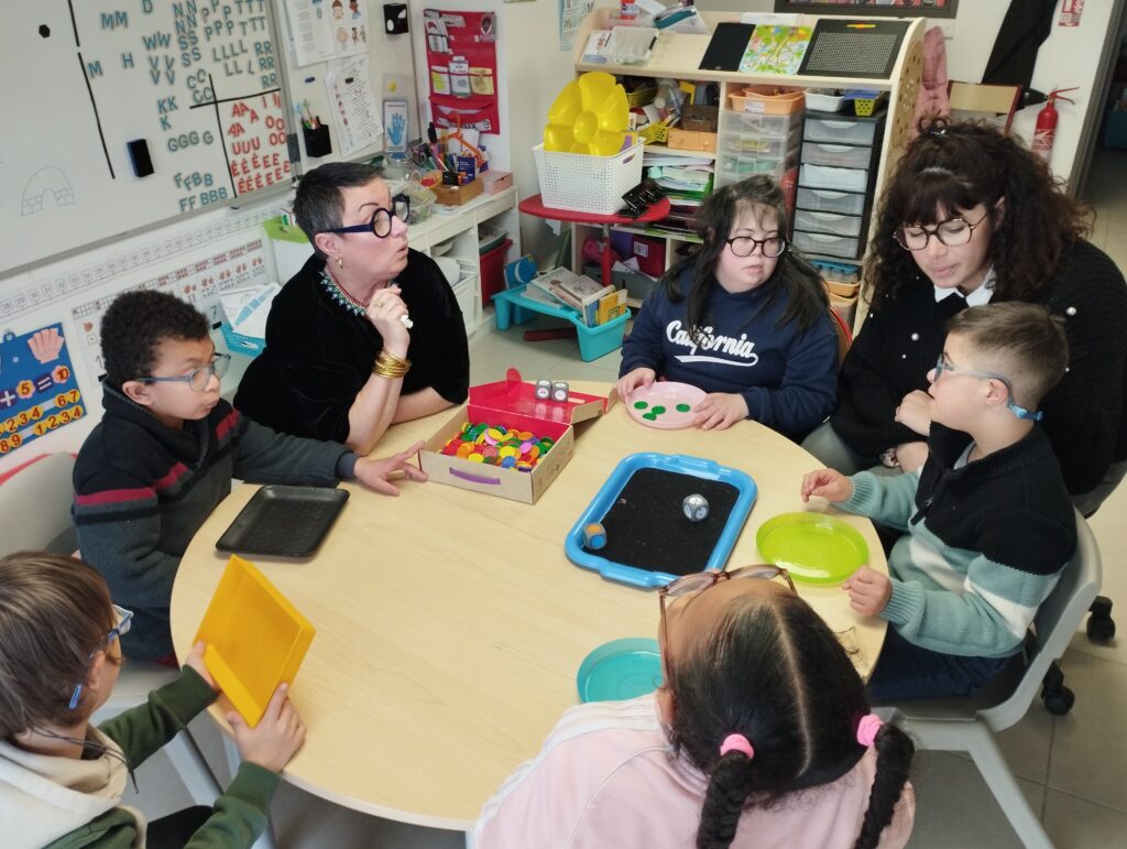 5 jeunes avec 2 de leurs encadrantes autour d'une table d'activités