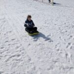 Un enfant descend une piste de luge