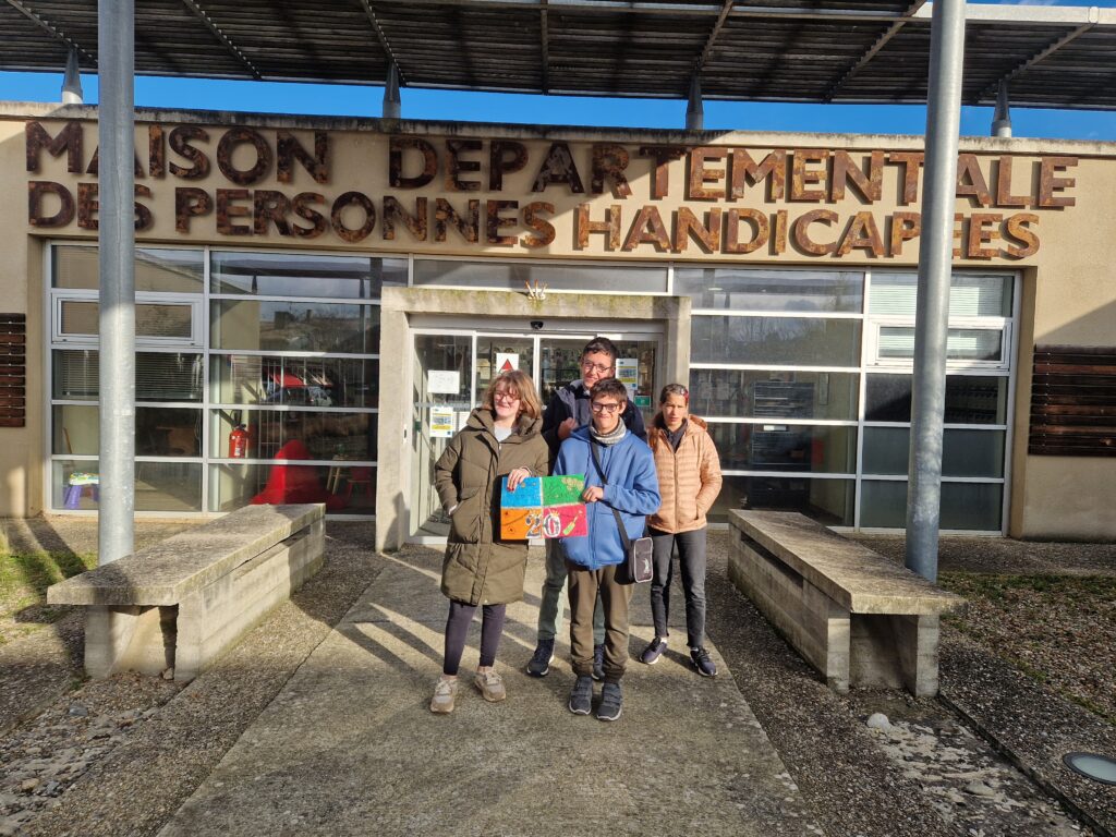 Les jeunes posent devant l'entrée de la MDPH avec leur dessin